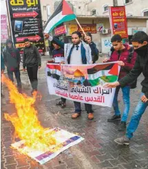  ?? SAÏD KHATIB AGENCE FRANCE-PRESSE ?? Des Palestinie­ns ont brûlé des drapeaux israéliens et des photos de Donald Trump, à Rafah, dans la bande de Gaza.