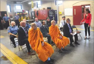  ??  ?? Woonsocket Mayor Lisa Baldelli-Hunt, right, chats with members of Woonsocket’s Wat Lao Xokexayarm Buddhist Temple, joined by members of the fire department as well as Public Safety Director Eugene Jalette, Police Chief Thomas Oates, and Fire Chief Paul Shatraw as members of the temple’s board of directors prepared to present the Woonsocket Fire Department with a donation check in appreciati­on for the all the department does for the city on Wednesday.