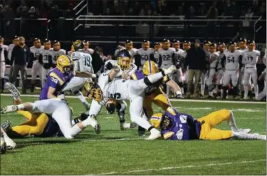  ?? ERIC BONZAR — THE MORNING JOURNAL ?? Olmsted Falls’ Luke Lombardo (5) is tripped up by Avon’s Joey Lance (1) during a Division II regional final.