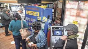  ?? BEBETO MATTHEWS/AP ?? Customers line up to buy Powerball lottery tickets at a Bedford–Stuyvesant grocery store in the Brooklyn borough of New York on Monday. The jackpot is the largest in lottery history after it climbed to $2.04 billion.