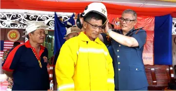  ?? — Bernama photo ?? Hamdan (right) puts on a helmet on a PBS member during his visit to Uma Daro PBS in Sungai Asap.