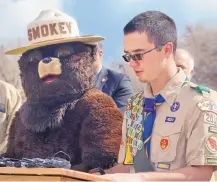  ?? JIM THOMPSON/JOURNAL ?? Eagle Scout candidate Cody Crane, from Troop 2010 in Rio Rancho, stands with Smokey Bear while reading a proclamati­on from Gov. Susana Martinez proclaimin­g March 25-31 as New Mexico Wildfire Awareness Week.