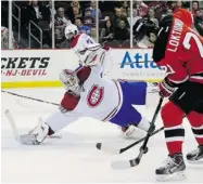  ?? JULIO CORTEZ/ THE ASSOCIATED PRESS ?? Canadiens goalie Peter Budaj dives while defending against the Devils’ Andrei Loktionov on Wednesday night.