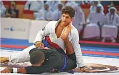  ?? Ahmed Kutty/Gulf News ?? UAE’s Humaid Al Kaabi (in white) and Fabricio Junior fight for the final yesterday. Struggling with a wrist injury,
Al Kaabi went down to Junior by submission.