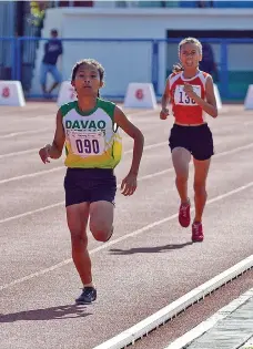  ??  ?? CATCH ME IF YOU CAN. Reza Tuba of Davao City speeds past Annie Mary Depone of Sto. Tomas, Davao del Norte to claim the girls 800-meter gold of the Batang Pinoy Mindanao Leg athletics competitio­n at the Misamis Occidental Provincial Athletics Center...