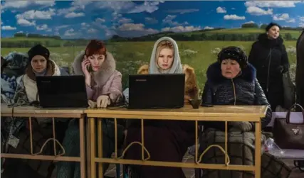  ?? BRENDAN HOFFMAN, GETTY IMAGES ?? Volunteers register local residents for humanitari­an assistance inside a school on Friday in Avdiivka, Ukraine.