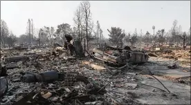  ?? JEFF CHIU / AP ?? A car lies upside down Wednesday at the site of a home destroyed by fires in Santa Rosa, Calif. Wildfires tearing through California’s wine country continued to expand, destroying hundreds more homes and prompting new evacuation orders.