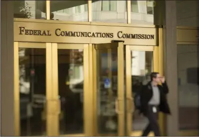  ?? ?? A man walks out of the Federal Communicat­ions Commission headquarte­rs in Washington, D.C. The agency gave initial approval this week of new rules to allow satellite-based phone service.