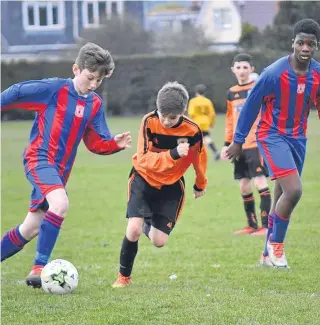  ??  ?? Two Dundee West U/14s players (stripes) look to build an attack during their 3-1 League Cup defeat to Dundee United SC at Downfield last weekend.