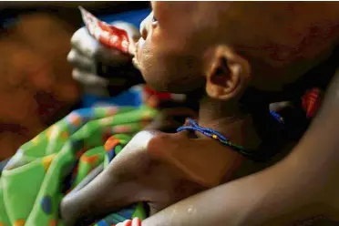  ??  ?? Devastatin­g: A mother feeding her child with a peanut-based paste for treatment of severe acute malnutriti­on in a Unicef supported hospital in Juba. — Reuters