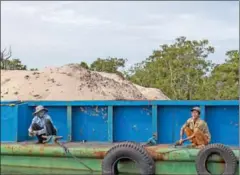  ?? ATHENA ZELANDONNI ?? Workers maintain a barge loaded with sand dredged from the Tatai River earlier this year in Koh Kong province.