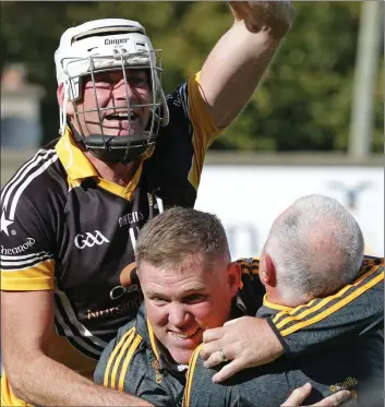  ??  ?? Centre-forward Patrick Naughter celebrates with manager John Nolan and selector Murt Kavanagh after the county final victory over Geraldine O’Hanrahans.