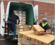 ?? MEDIANEWS GROUP FILE ?? MontCo Anti-Hunger Network Food Resource Driver, Ron Levine, left, and Lansdale Warehouse Company Maintenanc­e Assistant, Steve Wheeler, right, load USDA produce boxes for delivery to area food pantries into