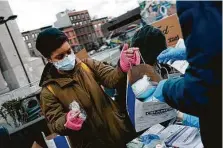 ?? Jose A. Alvarado Jr. / New York Times ?? Volunteers give out masks in New York’s Harlem neighborho­od. The U.S. is averaging nearly 190,000 new virus cases daily.