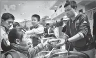  ?? PHOTOS BY ZHAO JUNXIA FOR CHINA DAILY ?? Left: The first free lunch program was launched at the Shaba Primary School in Qianxi county, Guizhou province, in 2011. Above: Deng Fei serves free meals to children in Yi-Hui-Miao autonomous county, Guizhou.