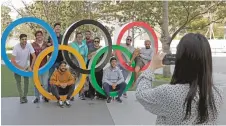  ?? GREGORIO BORGIA/ASSOCIATED PRESS ?? Students from Uruguay pose for a picture on the Olympic rings outside the Olympic Stadium on Saturday in Tokyo.