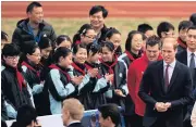  ?? AFP ?? Britain’s Prince William, right, talks to students during his visit to a training session of the Premier League football camp in Shanghai yesterday.