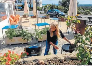  ?? SERGIO G. CAÑIZARES / EFE ?? Una mujer preparando la apertura de la terraza de un bar en Formentera.