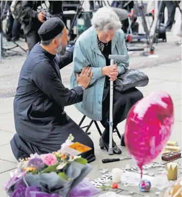  ??  ?? Sadiq Patel, a Muslim, was seen comforting Renee Rachel Black, a Jew, at the vigil held in Manchester’s Albert Square on Tuesday