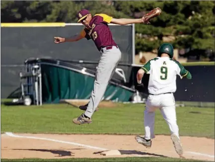  ?? JEN FORBUS — THE MORNING JOURNAL ?? Avon Lake first baseman Aidan Jantz jumps to make the catch, allowing Amherst’s Ryan Glowacki to make it to the bag safely on April 30.