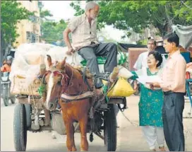  ??  ?? Kavita Dass reaching out to a cart owner and briefing him about horse care and welfare.