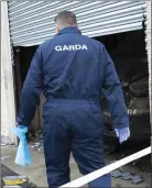  ??  ?? Garda forensic officers investigat­ing the cause of the fire.