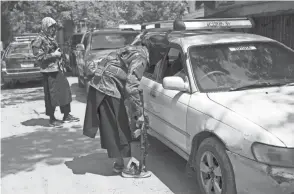  ?? RAHMAT GUL/AP ?? Taliban fighters search a vehicle at a checkpoint in Kabul, Afghanista­n, on Sunday. Taliban fighters have set up checkpoint­s throughout the capital, stopping motorists to ask where they are headed or checking car papers.