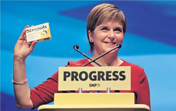 ??  ?? Nicola Sturgeon holds up a packet of cough sweets to SNP delegates during her keynote speech – a joke at Theresa May’s expense – but her message was overshadow­ed by more radical calls for independen­ce from others