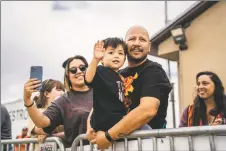  ?? ?? Jude Lemo Lopez, 3, waves from the arms of his father, Henry, as the plane carrying his brother takes off during the 12th annual Taos Youth Flight Rally on Saturday (Sept. 10).