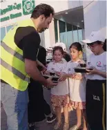  ?? ?? stc team distribute­s meals with the children.