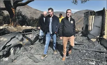  ?? Wally Skalij Los Angeles Times ?? GOV. GAVIN NEWSOM, center, looks over the fire devastatio­n in Brentwood with L.A. Mayor Eric Garcetti, right, and Councilman Mike Bonin, left rear. Newsom and the state face dual crises in blackouts and wildfires.