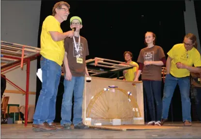  ?? ANDREA PEACOCK/The Okanagan Saturday ?? Peter Murray, a physics instructor at Okanagan College, and two Lumby students look at their spaghetti bridge built for the heavy weight competitio­n, which was cancelled because of technical difficulti­es Friday afternoon.