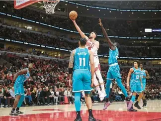  ?? JOHN J. KIM/CHICAGO TRIBUNE ?? Bulls guard Zach LaVine makes a spin move and scores past Hornets forward Cody Martin in the fourth quarter Friday at the United Center. LaVine scored 15 points in the Bulls’ 104-91 victory.