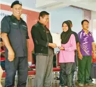  ??  ?? AWANG Zamri menyampaik­an anugerah peserta terbaik perkhemaha­n (perempuan) kepada Nadhirah Karmila Abd Motalip (PPIM) sambil diiringi Ramli (kiri).