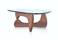  ?? MILLER HERMAN ?? This triangular glass table that sits on a wood base was designed by Japanese artist Isamu Noguchi. It was introduced in 1947 by Herman Miller.