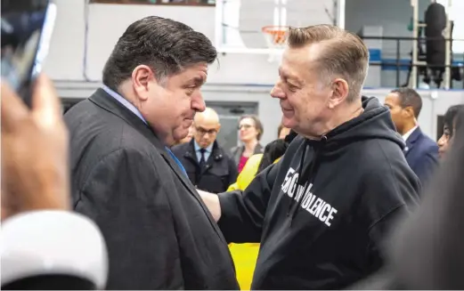  ?? PAT NABONG/SUN-TIMES ?? The Rev. Michael Pfleger speaks to Gov. J.B. Pritzker during a press conference at The Ark of St. Sabina in Auburn Gresham on May 18, where Pritzker signed a bill that bans the sale and possession of ‘‘ghost’’ guns.