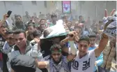  ??  ?? Le corps de Tahrir Wahba, un Palestinie­n de 18 ans décédé après avoir été blessé à la tête par des tirs israéliens lors d’affronteme­nts à la frontière entre la bande de Gaza et Israël, porté dans les rues de Khan Younès pendant ses funéraille­s, hier