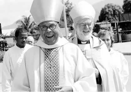  ?? FILE ?? The Rt Rev Alfred Reid, then Bishop of Jamaica and the Cayman Islands, leads then Archbishop of Canterbury the Most Rev Dr Rowan Williams towards the National Arena for a special church service in May 2009.