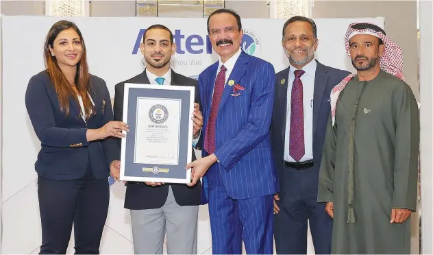  ?? ?? ↑
Dr Azad Moopen and Alisha Moopen being awarded the Guinness World Record Certificat­e.