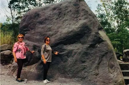  ??  ?? The author and Tintin touch the huge rock that resembles an ancient face. This stone was expelled from Mt. Merapi Volcano’s eruption