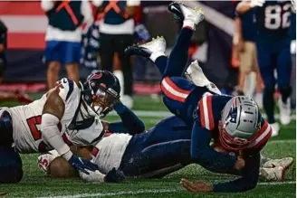  ?? BARRY CHIN/GLOBE STAFF ?? Quarterbac­k Malik Cunningham dives into the end zone on a 9-yard keeper for the Patriots’ only touchdown, scored late in the fourth quarter.