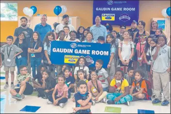  ?? Gaudin Ford ?? Former Vegas Golden Knight defenseman Ryan Reaves, Gaudin Ford executives, Boys & Girls Clubs staff and James Clubhouse youth celebrate the new game room.