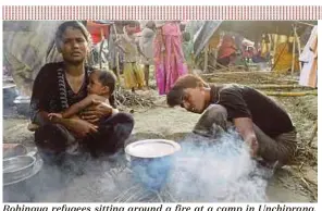  ?? AFP PIC ?? Rohingya refugees sitting around a fire at a camp in Unchiprang, near Teknaf, on Wednesday.