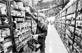  ?? RICK BOWMER/AP ?? Alan Stotts wears a mask as he shops Friday at Harmons grocery store in Salt Lake City.