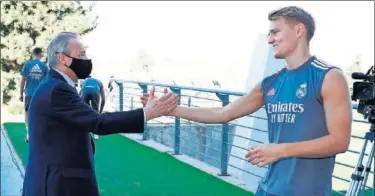  ??  ?? Florentino saluda a Odegaard, la principal novedad de la plantilla esta temporada.