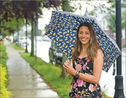  ?? SEAN D. ELLIOT/THE DAY ?? Children’s book author Abi Cushman stands on Main Street in Niantic. Her first book, “Soaked!,” was inspired by a rain-soaked walk down that same street.