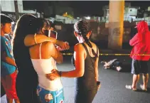  ??  ?? RESIDENTS LOOK at the body of a man who police said was killed in a spate of drug-related violence in Manila, Aug. 16.