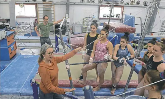  ?? Lake Fong/Post-Gazette ?? Elaine Jewart, left, owner of Jewart's Gymnastics, talks to a group of gymnasts in her facility in Hampton. Ms. Jewart, now 73, has been running a gymnastics program since launching one in her basement in 1969. Visit for a video report.