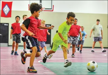  ?? (River Valley Democrat-Gazette/Hank Layton) ?? Darien Smith (center), 8, and others play soccer Thursday at the Evans Boys & Girls Club in Fort Smith. Visit nwaonline.com/photo for today’s photo gallery.