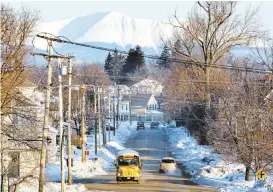  ?? ROBERT F. BUKATY/ASSOCIATED PRESS ARCHIVES ?? Mount Katahdin rises in the background as a school bus makes its rounds in Millinocke­t, Maine, in 2011. President Barack Obama created the Katahdin Woods and Waters National Monument that could bring 450 jobs to the area.